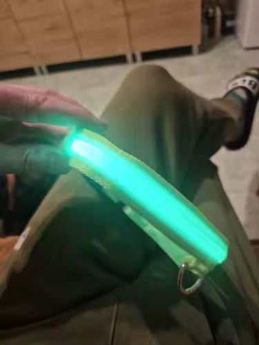 Collier lumineux vert allumé tenu à la main